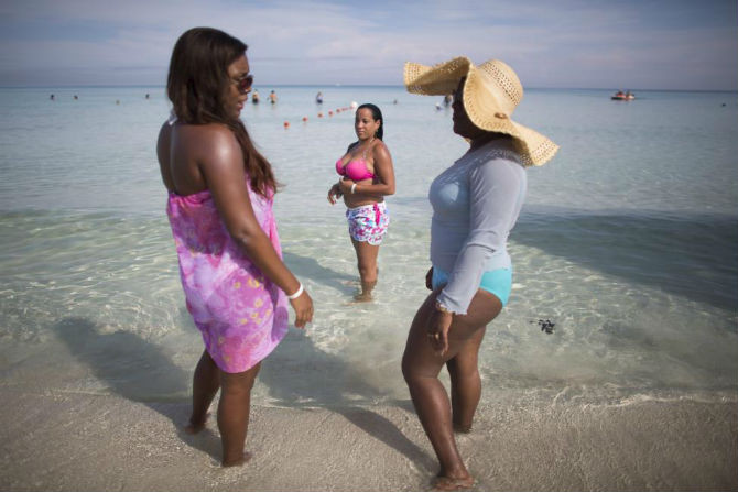 Nhân viên hành chính Carmen Oivedo (trái) trò chuyện với con gái khi họ đi nghỉ mắt tại bãi biển ở Varadero ngày 26/8/2015.