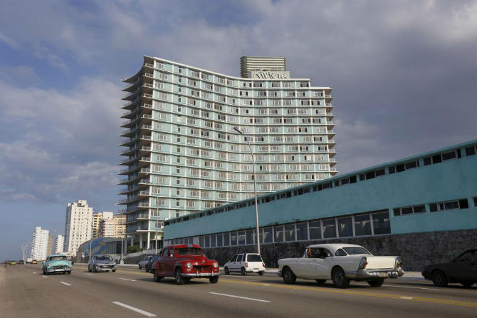 Những chiếc ô tô cổ điển xuất hiện trên đường phố La Habana, phía sau là khách sạn Riviera. Ảnh chụp ngày 9/12/2015.
