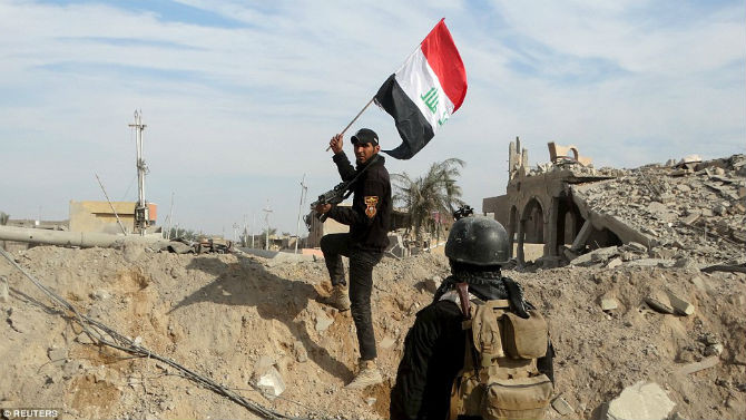 Một chiến binh Iraq giơ cao quốc kỳ nước này trong thành phố Ramadi.