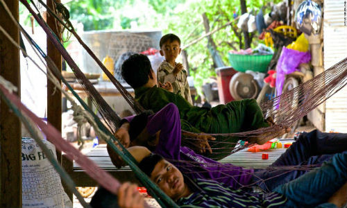 Bức ảnh chụp người cha đang trò chuyện với con trai khi đang nằm trên võng mắc ngoài nhà ở Xiêm Riệp.