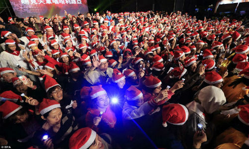Hàng trăm người dân mặc trang phục ông già Noel và hát bài hát về Giáng sinh vào đêm Giáng sinh tại một một công viên của thành phố Đài Bắc mới, Đài Loan.