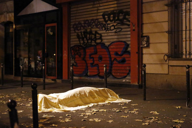 Thi thể của một nạn nhân vụ khủng bố ở Paris (Pháp) nằm bên ngoài nhà hát Bataclan ngày 13/11/2015. 7 kẻ tấn công mang bom và vũ khí tự động tấn công vào nhiều địa điểm khác nhau ở Paris, khiến 130 người thiệt mạng và hàng trăm người bị thương. Phiến quân IS đã lên tiếng nhận trách nhiệm vụ tấn công tàn bạo này.
