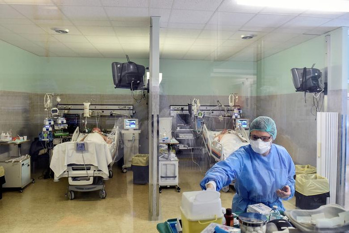 Nhân viên y tế đeo khẩu trang và mặc đồ bảo hộ khi điều trị cho các bệnh nhân Covid-19 tại bệnh viện ở Italy.