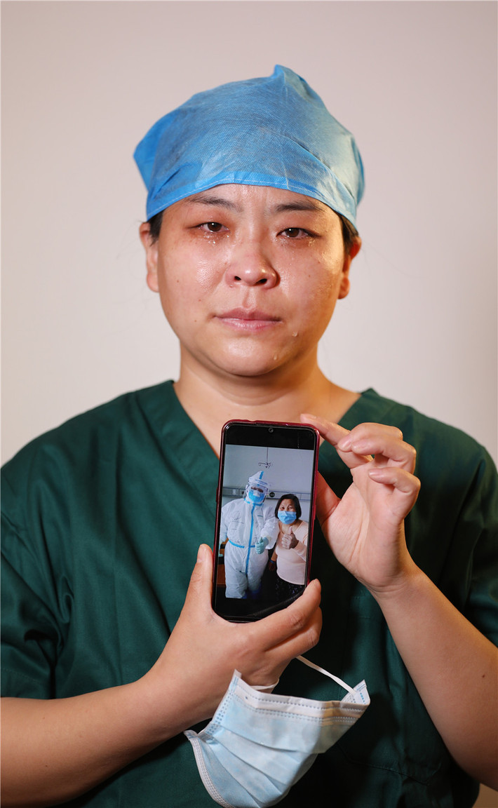 Y tá Kong Yaya đến từ bệnh viện thuộc Trường Cao đẳng Y Changzhi ở Sơn Tây xúc động giơ tấm hình chụp cùng bệnh nhân.
