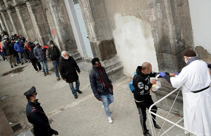 Người nghèo và người vô gia cư xếp hàng nhận đồ ăn được phân phát ở Naples, Italy - "ổ dịch" Covid-19 lớn nhất châu Âu - ngày 27/3.