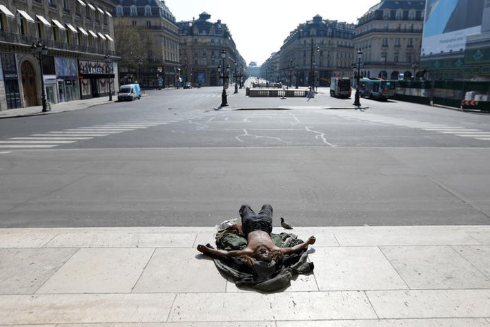 Người đàn ông vô gia cư nằm ngoài đường gần quảng trường vắng vẻ ở thủ đô Paris, Pháp, hôm 27/3.