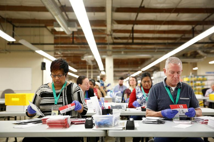 Các nhân viên chuẩn bị lá phiếu trong trung tâm King County Elections ở Renton.
