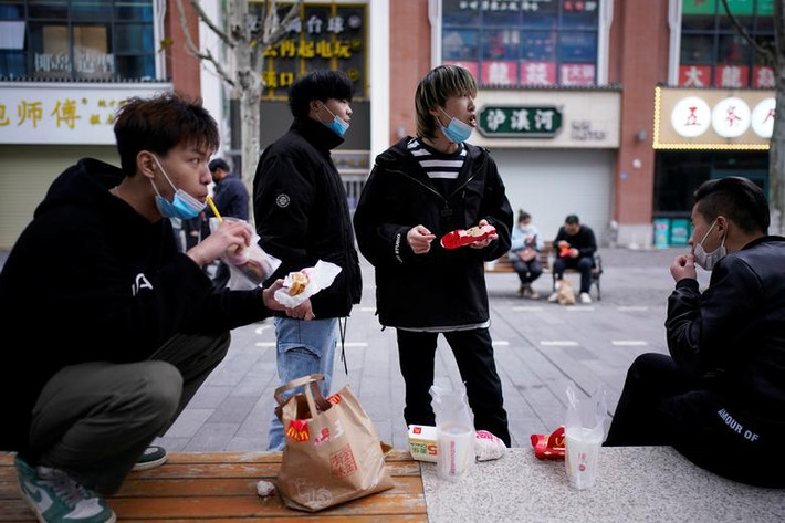 Người dân ngồi ăn bên ngoài một nhà hàng McDonald ở Vũ Hán hôm 30/3.