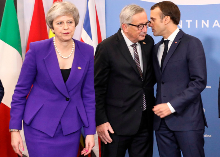Thủ tướng Anh Theresa May đi phía trước khi Tổng thống Pháp Emmanuel Macron và Chủ tịch Ủy ban Châu Âu Jean-Claude Juncker đang “thì thầm” phía sau. Được biết, EU và Anh đã đạt được một thỏa thuận về Brexit (Anh rời EU), nhưng Tổng thống Macron đe dọa sẽ “đánh chìm” thỏa thuận này bằng cách yêu cầu quyền đánh bắt cá trong vùng biển của Anh.
