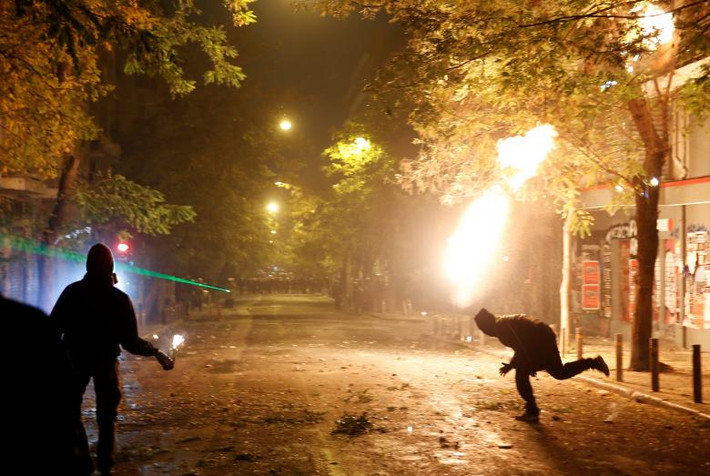 Một người biểu tình ném bom xăng về phía cảnh sát chống bạo động ở thủ đô Athens.