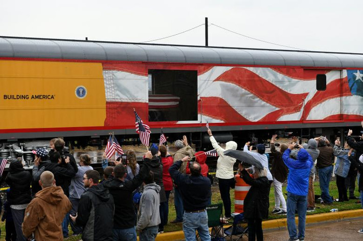 Người dân vẫy cờ khi chuyến tàu tang lễ chở cựu Tổng thống George H.W. Bush đi qua Navasota, bang Texas.