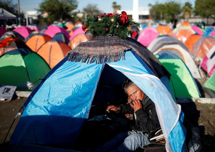 Một di dân ngồi trong túp lều tạm bợ trên đường phố Tijuana ngày 9/12.