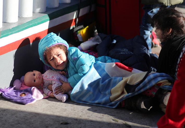 Nét mặt sợ hãi của một em nhỏ khi nằm chờ ở cửa khẩu El Chaparral giữa Mỹ và Mexico ở Tijuana ngày 9/12.