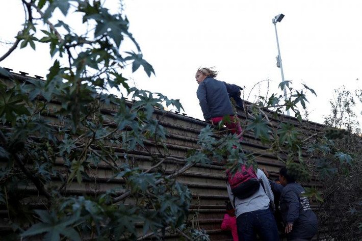 Một số di dân trèo qua hàng rào biên giới Mỹ-Mexico ngày 15/12.