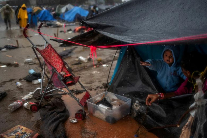 Nguyên nhân khiến khu trại bị ngập là do những trận mưa lớn kéo dài ở Tijuana. Ảnh: Bé Jonathan, 1 tuổi đến từ Honduras, đứng trong túp lều của gia đình tránh mưa.
