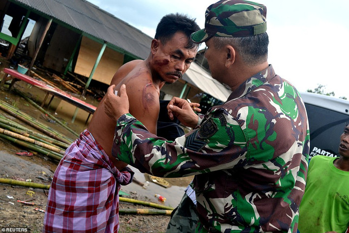 Số thương vong có thể còn gia tăng do nhiều khu vực bị ảnh hưởng chưa được đánh giá thiệt hại. Ảnh: Binh sĩ Indonesia xem vết thương cho một cư dân địa phương ở huyện Tanjung Lesung. Ảnh: Reuters.