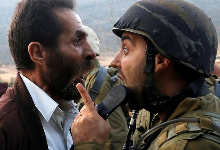 Một người đàn ông Palestine “đấu khẩu” với binh sĩ Israel trong cuộc đụng độ sau khi Israel quyết định đóng cửa một trường học Palestine gần Nablus, Bờ Tây, ngày 15/10.