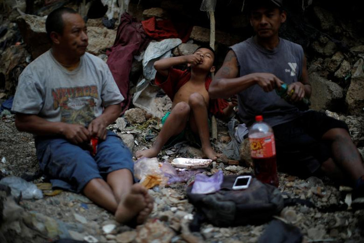 Bé Mauricio, 10 tuổi, cùng vài người khác ăn trưa ngay tại “nơi làm việc”.