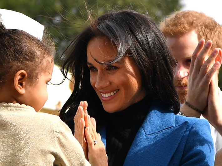 Hoàng tử Harry đã lấy tay vuốt tóc cho Meghan Markle khi tóc cô bị rối.