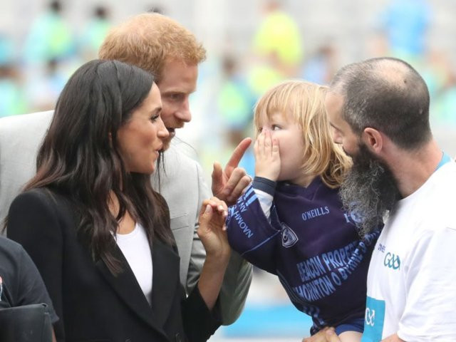 Vợ chồng Hoàng tử Harry trêu đùa bé Walter Cullen, 3 tuổi, khi tới sân vận động Croke Park ở Dublin, Ireland.