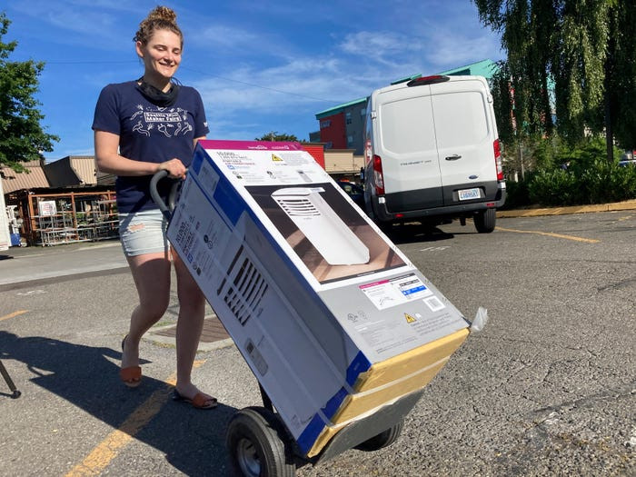 Sarah O'Sell chuyển chiếc máy lạnh mới mua về nhà ở Seattle ngày 25/6.