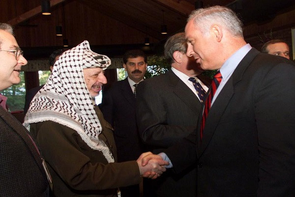 Thủ tướng Israel Netanyahu (phải) bắt tay Tổng thống Palestine Yasser Arafat (trái) trong ngày thứ 8 của Hội nghị Hòa bình Trung Đông diễn ra tại trung tâm hội nghị Wye River ngày 22/10/1998.