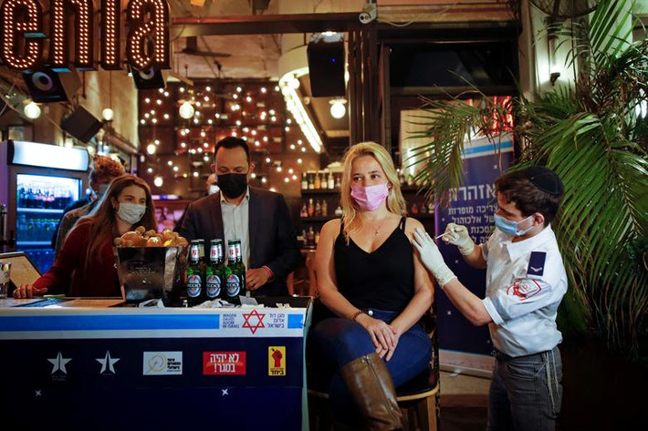 Người phụ nữ được tiêm vắc xin tại một quán bar ở Tel Aviv, Israel, ngày 18/2.