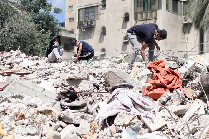 Người đàn ông Palestine tìm những đồ còn dùng được giữa đống đổ nát ở thành phố Gaza hôm 2/6.