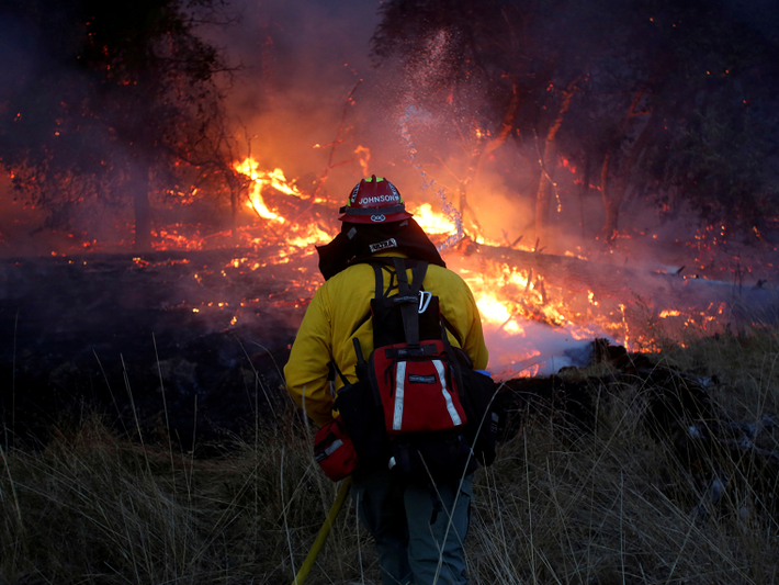 Lính cứu hỏa chiến đấu với đám cháy rừng gần Santa Rosa, bang California, Mỹ, ngày 15/10. Ảnh: Reuters.