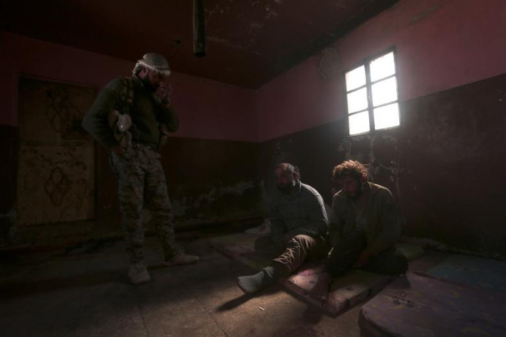 Hai tay súng IS bị lực lượng SDF bắt sống ở phía bắc thành phố Raqqa, nơi từng được coi là thủ phủ của nhóm khủng bố IS tại Syria, hôm 8/3. Ảnh: Reuters.