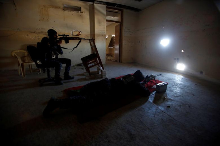 Cảnh sát Liên bang Iraq ngắm bắn các tay súng IS ở thành phố Mosul, Iraq, hôm 25/3. Ảnh: Reuters.