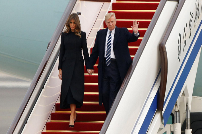 Tổng thống Trump nắm tay Đệ nhất phu nhân Melania bước xuống chiếc Không lực Một tại Sân bay Quốc tế Bắc Kinh ngày 8/11. Ảnh: Reuters.