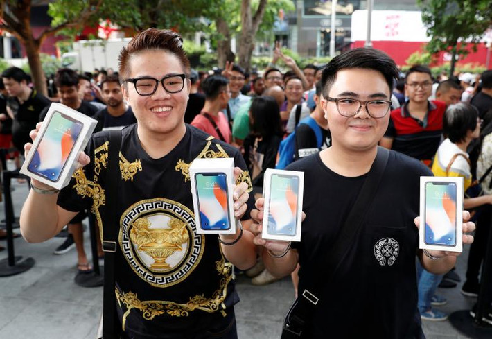 Kittiwat Wang, 22 tuổi, và Mod, 22 tuổi, đến từ Bangkok chụp ảnh với chiếc iPhone X vừa mua được tại cửa hàng Apple ở Singapore. Ảnh: Reuters.