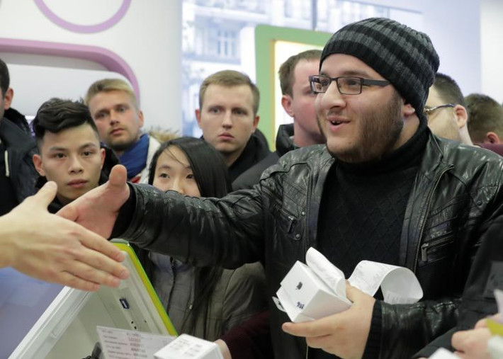 Khách hàng bắt tay nhân viên cửa hàng Apple ở Moscow sau khi mua được iPhone X. Ảnh: Reuters.