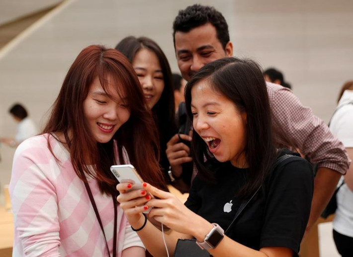 Cô gái vui mừng khi cầm chiếc iPhone X tại cửa hàng ở Singapore. Ảnh: Reuters.