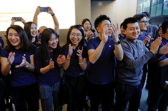 Các nhân viên cửa hàng Apple chào đón khách hàng ở Bắc Kinh, Trung Quốc. Ảnh: Reuters.