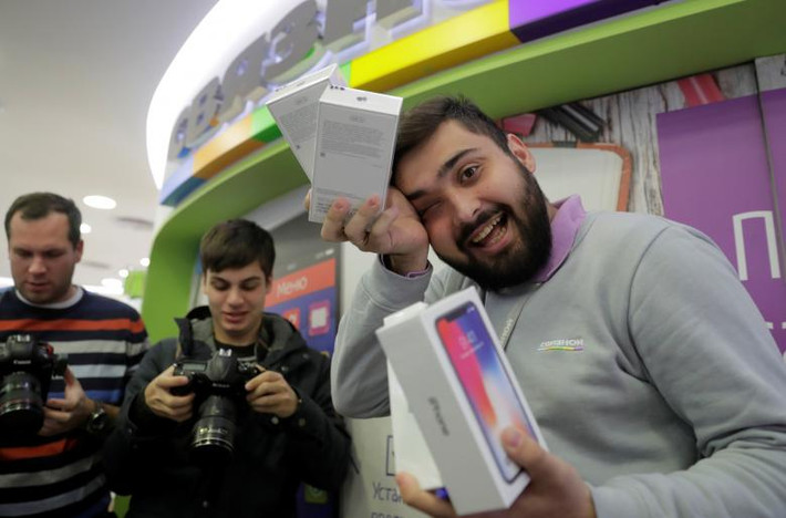 Một nhân viên tại cửa hàng Apple ở Moscow, Nga, cầm hộp đựng chiếc iPhone X trên tay. Ảnh: Reuters.