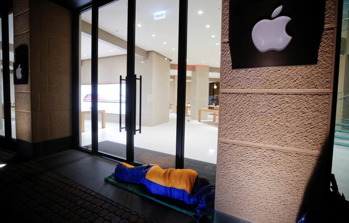 Người đàn ông nằm ngủ phía trước cửa hàng Apple ở Cologne, Đức, để có thể trở thành một trong những người sở hữu iPhone X đầu tiên. Ảnh: Reuters.