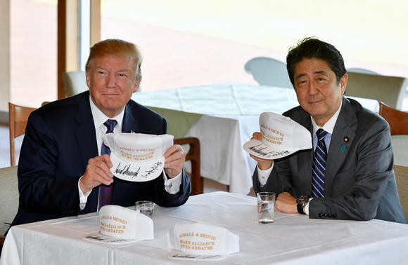 Tổng thống Trump và Thủ tướng Abe cầm chiếc mũ có dòng chữ “Donald và Shinzo cùng giúp mối liên minh trở nên tốt đẹp hơn” tại câu lạc bộ Quốc gia Kasumigaseki ngày 5/11. Ảnh: Pool/Reuters.