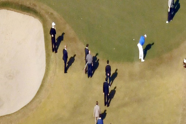 Ảnh chụp từ trên cao cho thấy Tổng thống Mỹ Donald Trump đang chơi golf cùng Thủ tướng Abe và Hideki Matsuyama trong khi nhiều người khác đứng xem. Ảnh: AP.