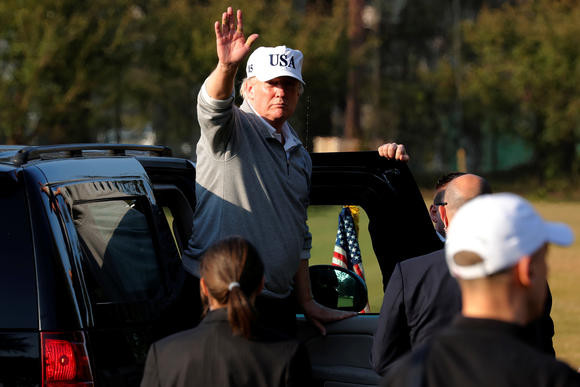 Nhà lãnh đạo Mỹ vẫy chào mọi người sau buổi chơi golf. Ảnh: Reuters.