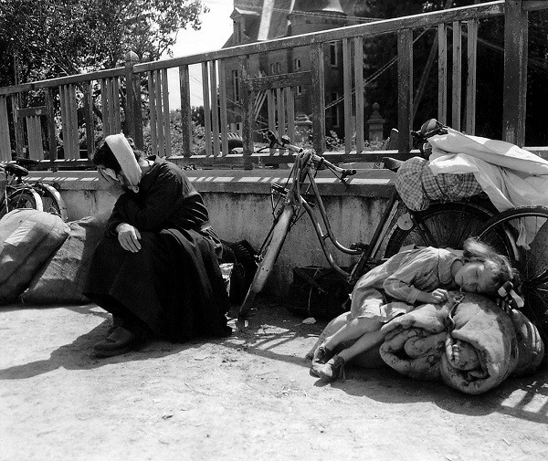 Người tị nạn ngồi nghỉ trên đường đi lánh nạn ở Pháp ngày 10/8/1944. Được biết, nhiều người dân tháo chạy khỏi Mortaine đã tìm đường tới Saint-Pois để xin tị nạn hồi tháng 8/1944. Ảnh: Getty Images.