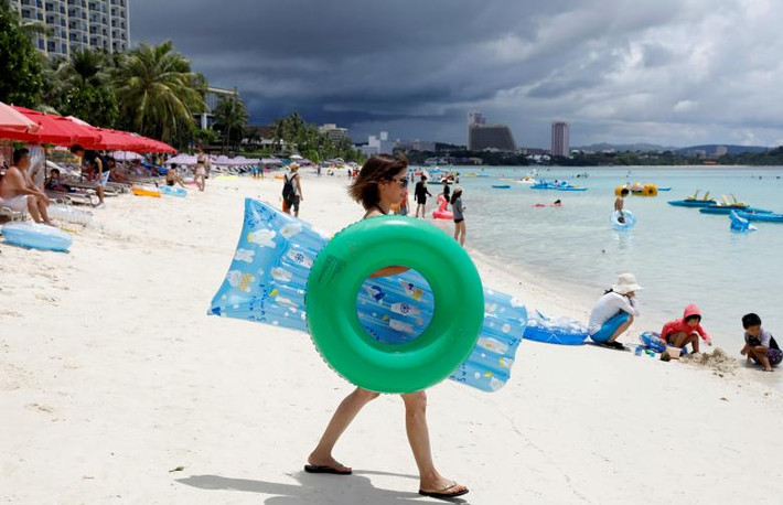 Hãng tin Reuters đăng tải loạt ảnh phần nào cho thấy cuộc sống trên đảo Guam vẫn diễn ra bình thường trong bối cảnh Bình Nhưỡng “dọa” tấn công đảo này sau tuyên bố của Tổng thống Mỹ Donald Trump về việc đáp trả Bình Nhưỡng bằng "lửa và sự cuồng nộ". Ảnh: Các du khách trên bãi biển Tumon ở đảo Guam ngày 10/8. Ảnh: Reuters.