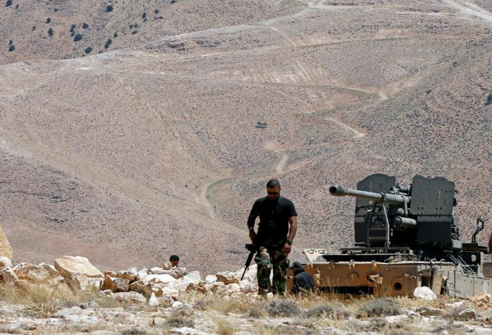 Một chiến binh Hezbollah mang theo vũ khí tuần tra ở khu Juroud Arsal. Ảnh: Reuters.