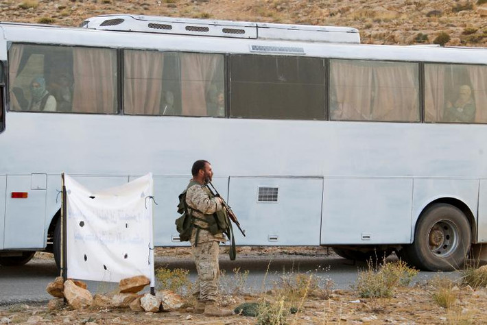 Một chiến binh Hezbollah đứng gần chiếc xe buýt ở Jroud Arsal. Ảnh: Reuters.