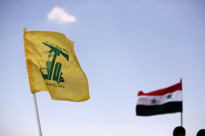 Cờ Syria và phong trào Hezbollah tung bay ở Fleita. Ảnh: Reuters.