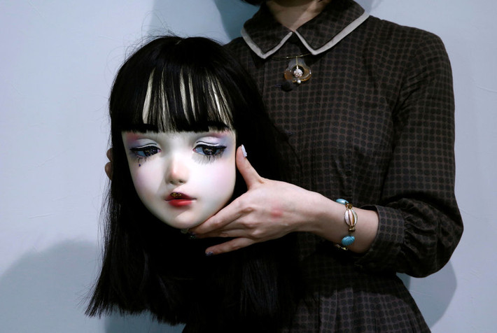 Nhà thiết kế Hitomi chụp ảnh cùng mặt nạ Lulu Hashimoto do cô thiết kế hôm 23/8. Ảnh: Reuters.