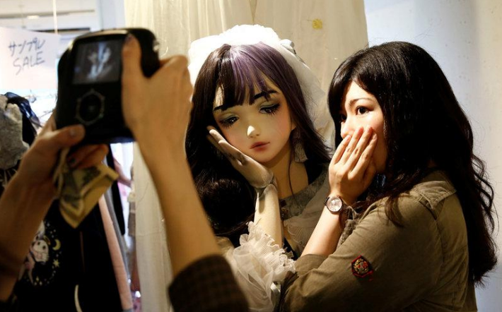 Cô gái chụp ảnh lưu niệm cùng cô người mẫu đặc biệt. Ảnh: Reuters.