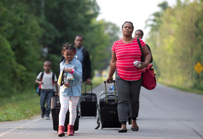 Một gia đình tị nạn Haiti trên đường vượt biên từ Mỹ sang Canada. Theo Reuters, hàng trăm người Haiti đã vượt biên vào Quebec để xin tị nạn trong những tuần gần đây khiến tỉnh này phải huy động thêm nhân viên dịch vụ biên giới từ các tỉnh khác đến hỗ trợ.
