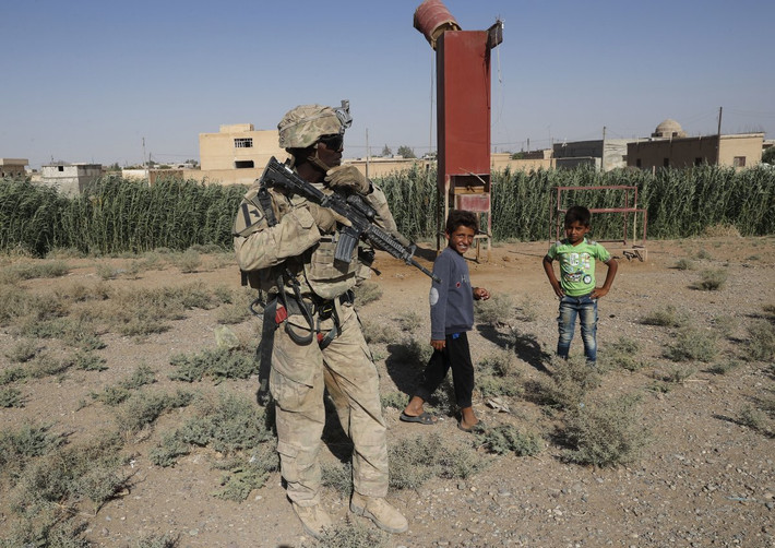 Khoảng 1.000 binh sĩ Mỹ tại Syria đang làm nhiệm vụ cố vấn và hỗ trợ cho lực lượng SDF. Ảnh: Binh sĩ Mỹ đứng trên một con đường ở ngoại ô thành phố Raqqa. Ảnh: AP.